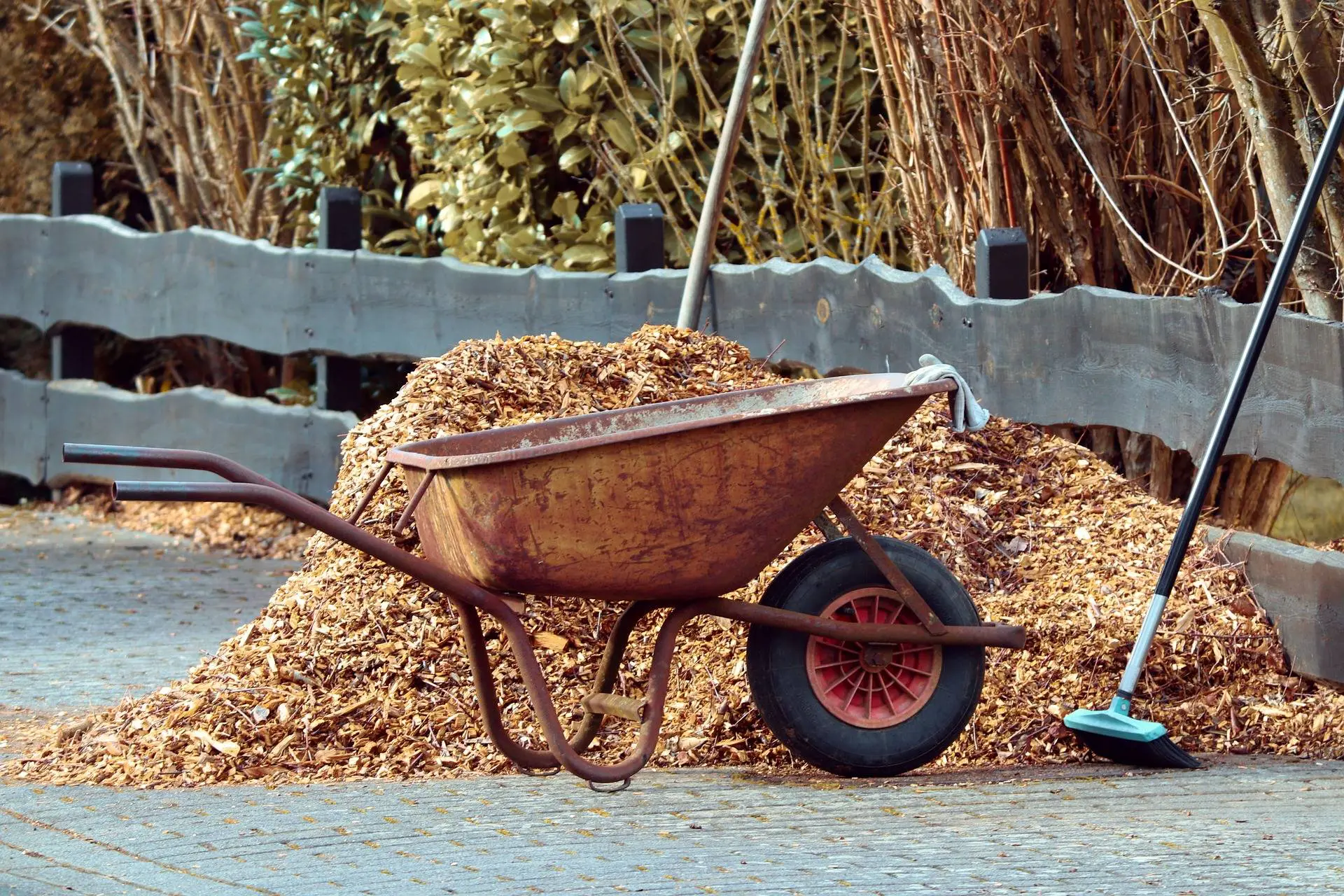 Eine Schubkarre steht vor einem großen Haufen Mulch